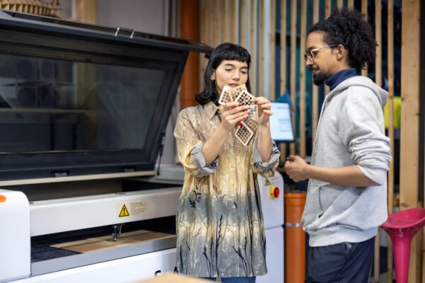 Photo of a man and woman looking at a wood design