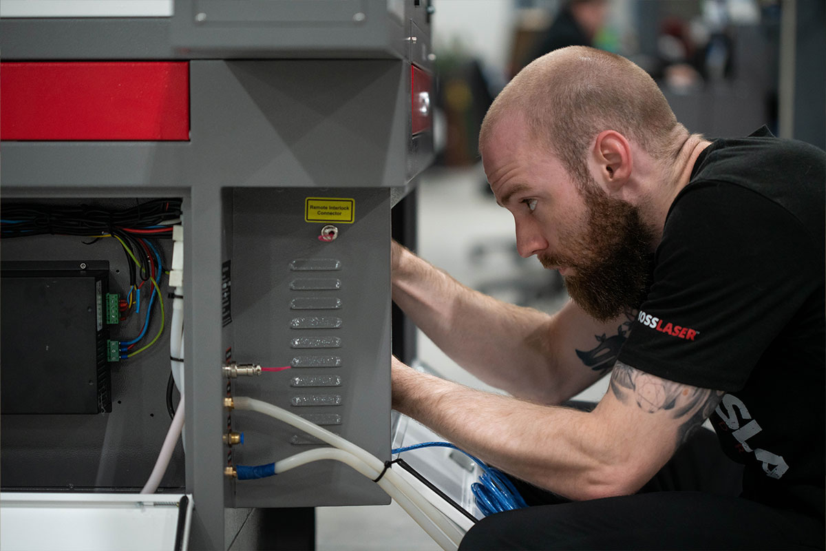 Photo of Boss laser employee working with laser cutting machine